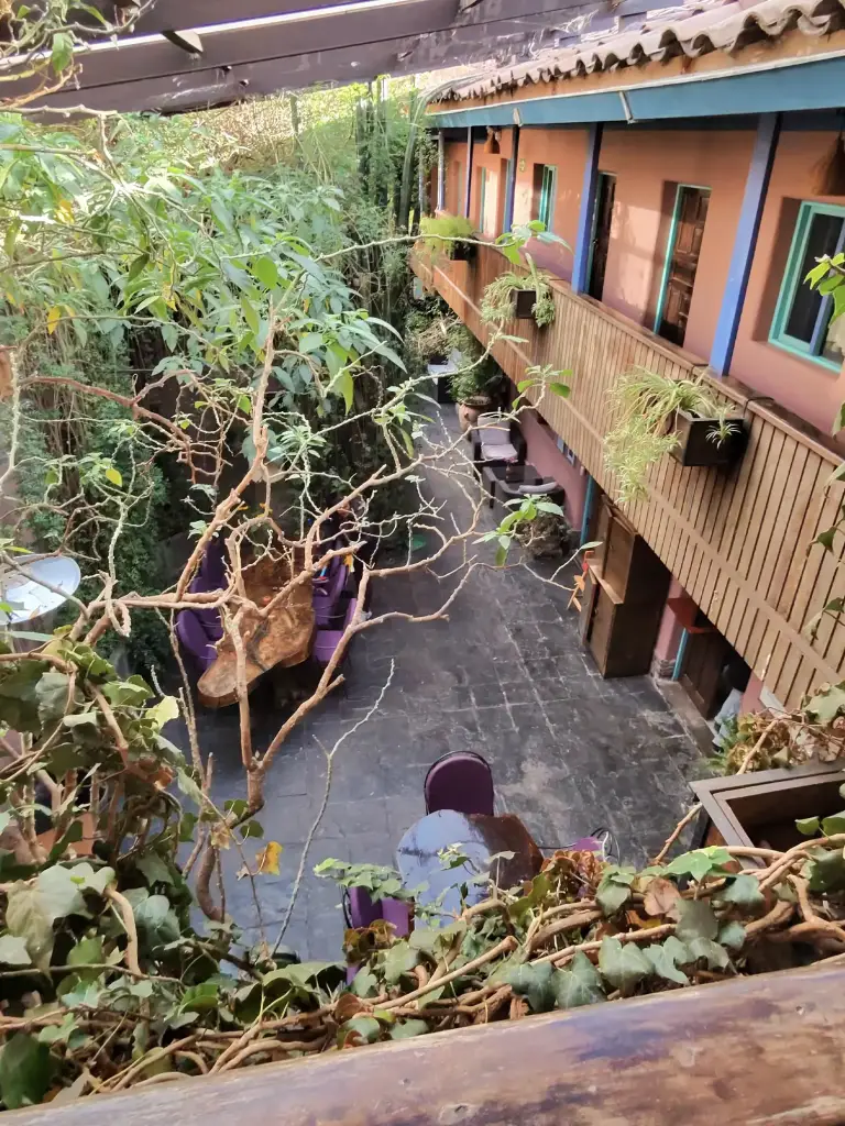 Inner courtyard of a traditional inn surrounded by greenery during a motorcycle trip across South America.