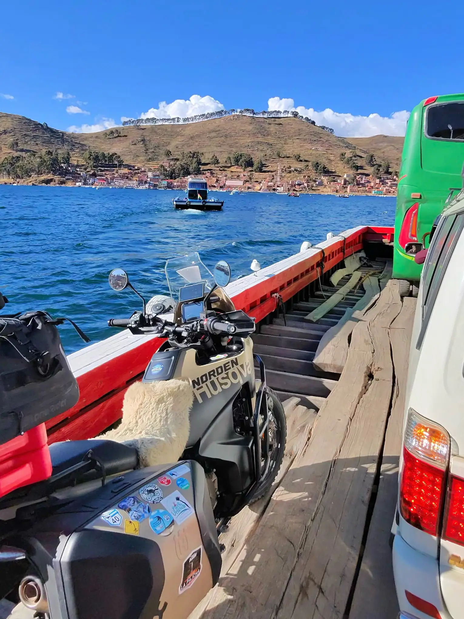 Motorcycle on wooden ferry crossing Lake Titicaca during motorcycle trip from Santa Cruz de la Sierra to Lima